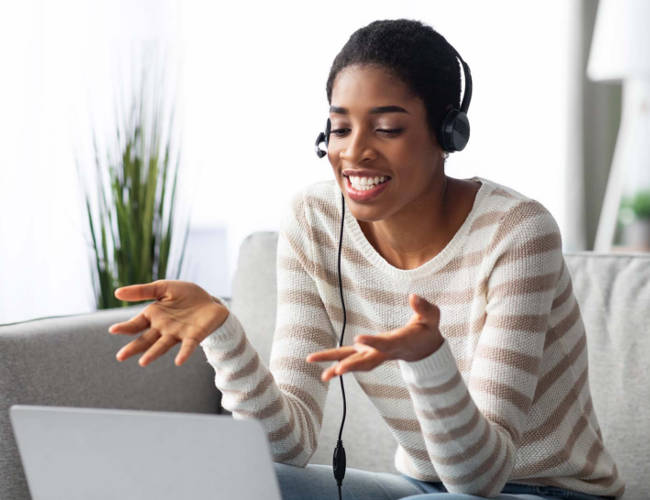 Woman in online virtual job interview waving her hand.