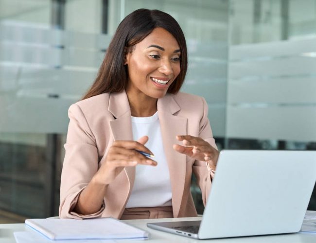 Woman in online virtual job interview waving her hand.